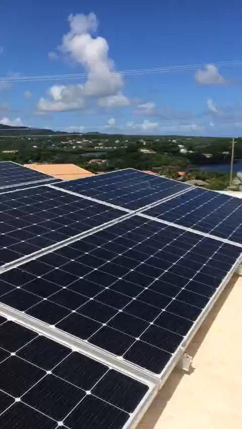 Painéis solares num telhado com vista sobre a costa