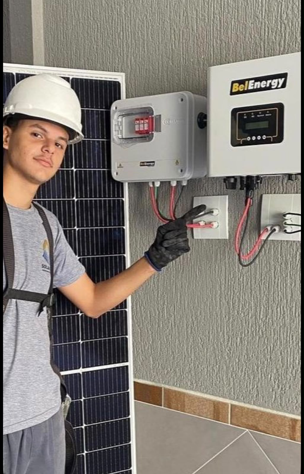Técnico a fazer manutenção a inversor e ligações elétricas de sistema solar